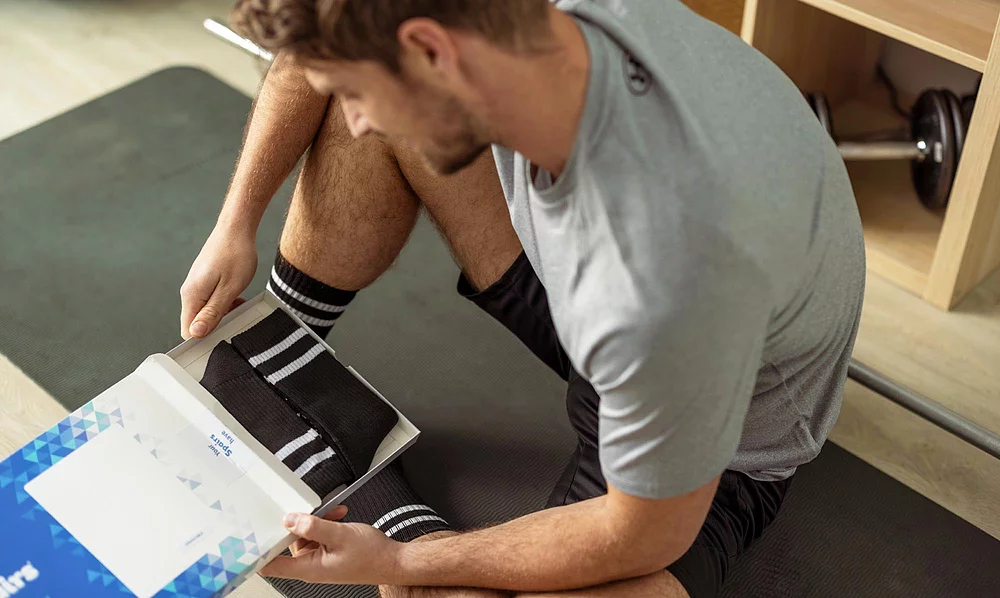 Man holding a multipack of cushioned sports socks