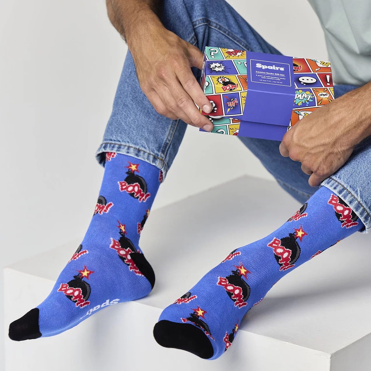 Man holding comics novelty socks gift box